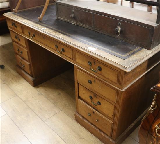 A late Victorian oak nine drawer pedestal desk, 153cm wide